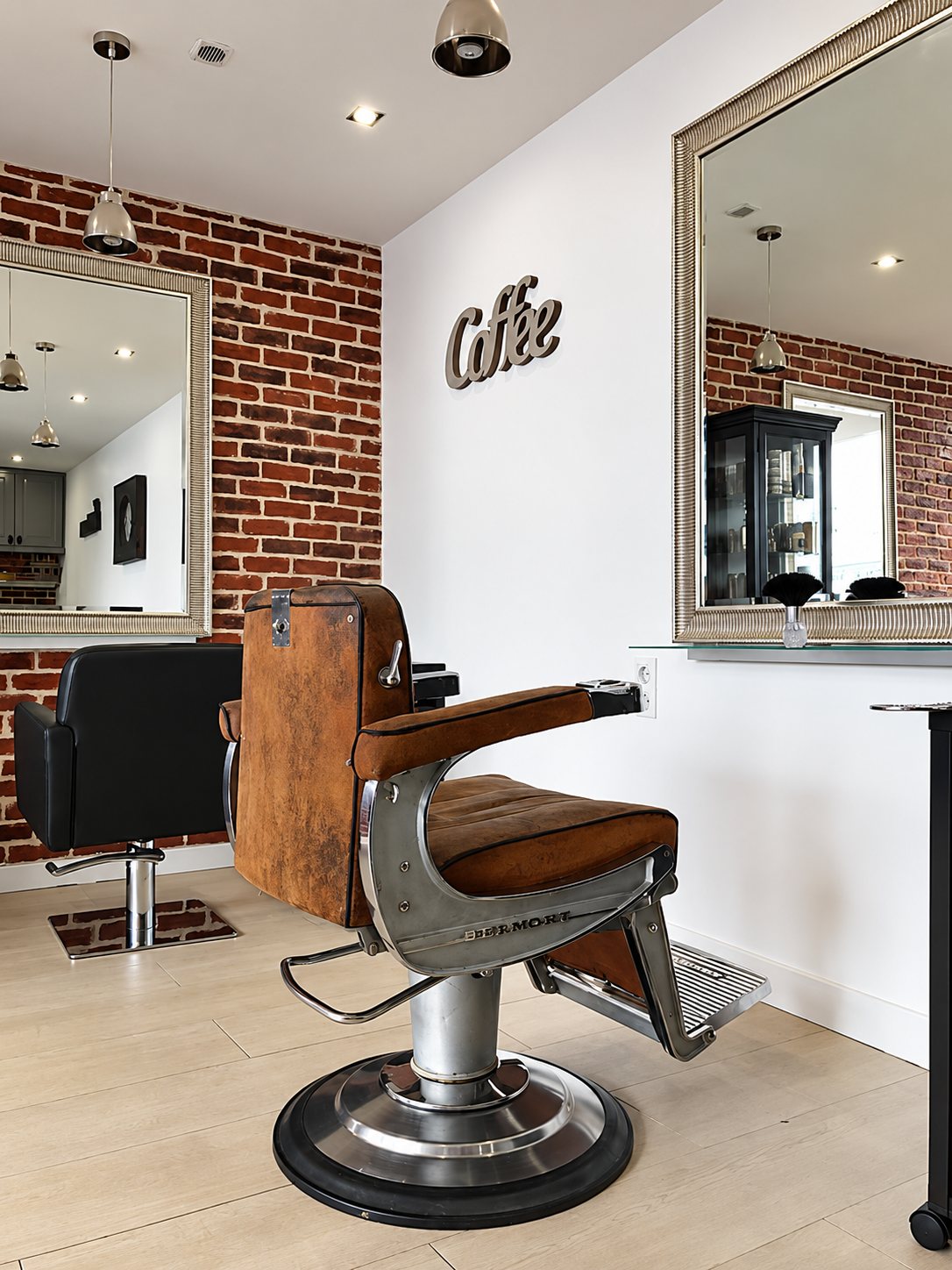 Fauteuil de barbier vintage en cuir brun devant les miroirs et le mur de briques du salon.
